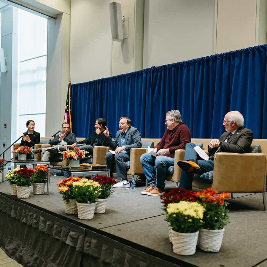 panelists on podium at the AI Powered World Symposium 2023